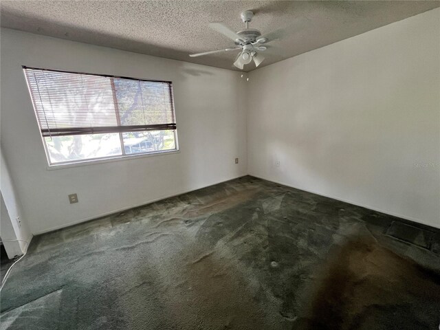 spare room with carpet flooring, ceiling fan, and a textured ceiling