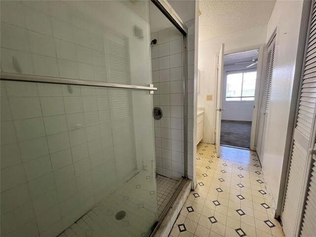 full bath featuring a shower stall, a textured ceiling, and tile patterned flooring