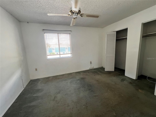 182 114th Ter NE Unit 182, Saint Petersburg, FL 33716 - unfurnished bedroom with dark colored carpet, multiple closets, a textured ceiling, and a ceiling fan
