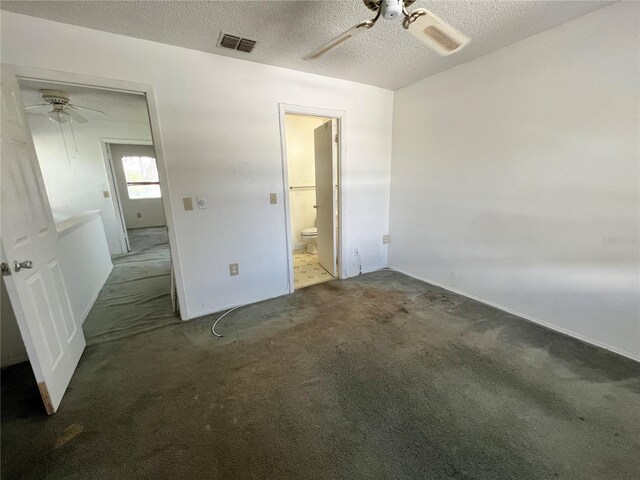 unfurnished bedroom with visible vents, ensuite bath, ceiling fan, dark colored carpet, and a textured ceiling