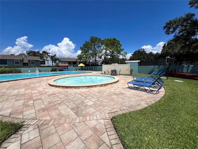 community pool featuring a yard, a patio area, and fence