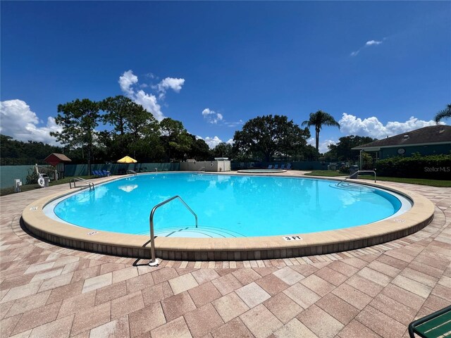 community pool featuring a patio and fence