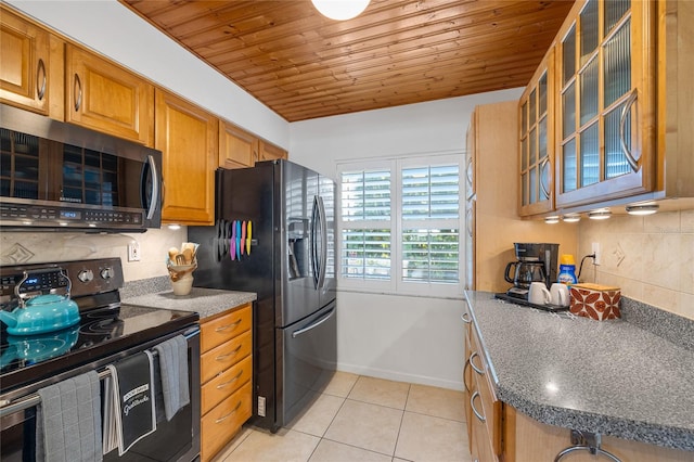 kitchen featuring wood ceiling, black fridge, tasteful backsplash, electric range oven, and light tile patterned floors