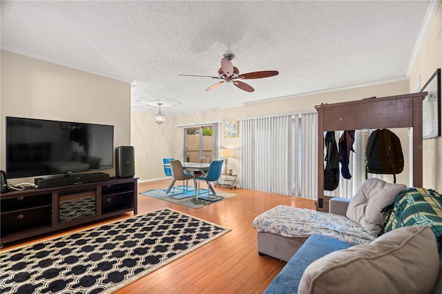 living area with wood-type flooring, crown molding, a textured ceiling, and ceiling fan