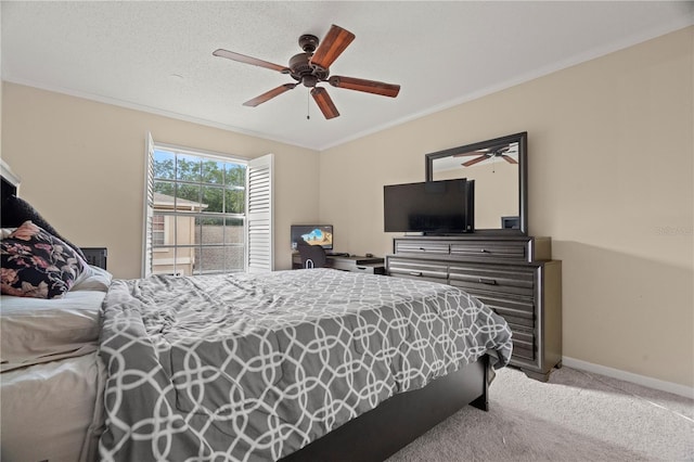 carpeted bedroom featuring baseboards, a textured ceiling, a ceiling fan, and crown molding