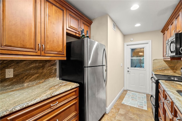 kitchen featuring tasteful backsplash, baseboards, brown cabinetry, light stone counters, and black appliances