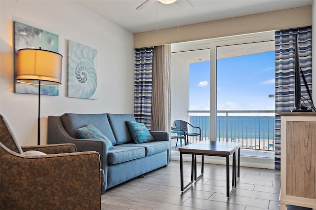 living room with a water view, ceiling fan, and wood-type flooring