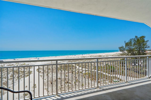 balcony featuring a water view and a beach view