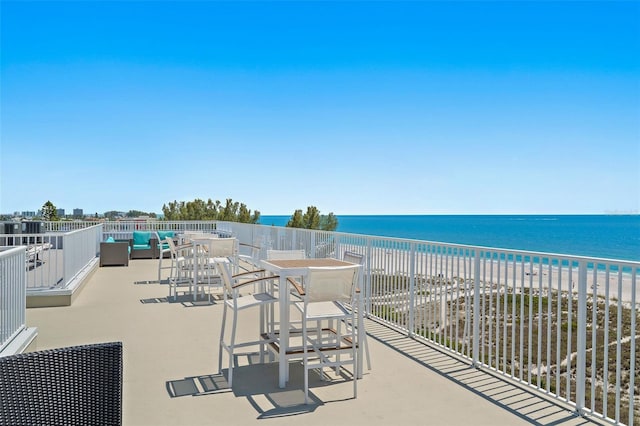 view of patio with a balcony, a view of the beach, and a water view