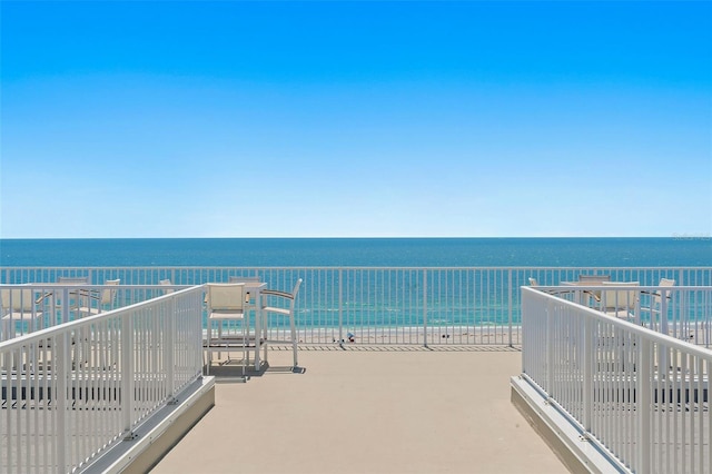 balcony featuring a water view and a beach view