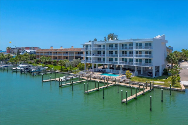 view of building exterior featuring a community pool and a water view