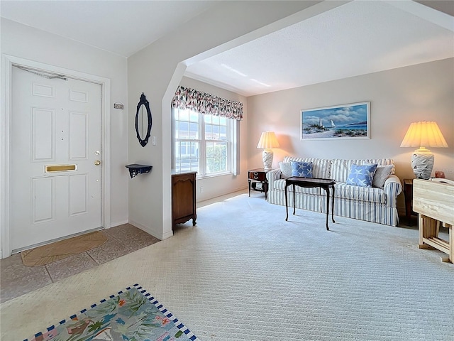 foyer featuring light carpet and baseboards