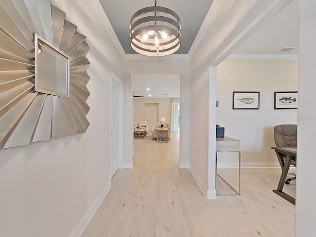 corridor with a chandelier, ornamental molding, and light wood-type flooring