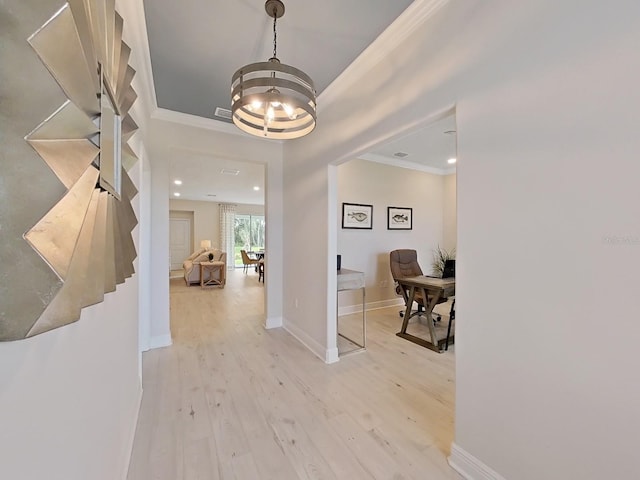 foyer entrance featuring light hardwood / wood-style flooring, a notable chandelier, and ornamental molding