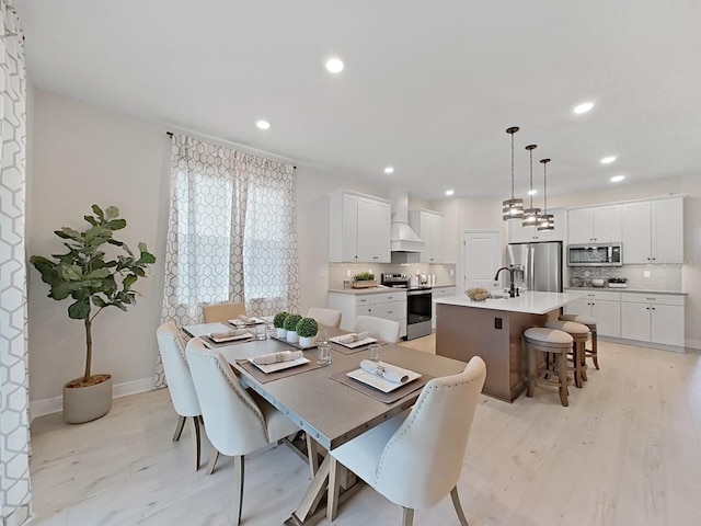 dining area featuring sink and light hardwood / wood-style flooring