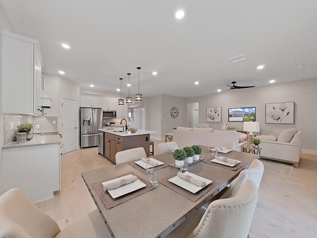 dining space with sink and light hardwood / wood-style floors