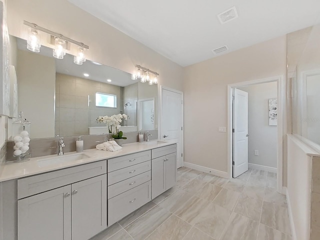 bathroom featuring tile patterned floors, a tile shower, and vanity