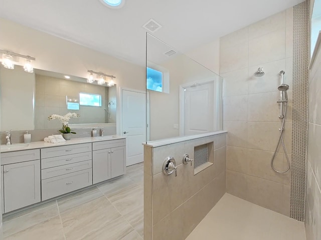 bathroom featuring tiled shower, tile patterned flooring, and vanity