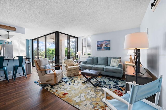 living room featuring dark wood-type flooring, a textured ceiling, and expansive windows