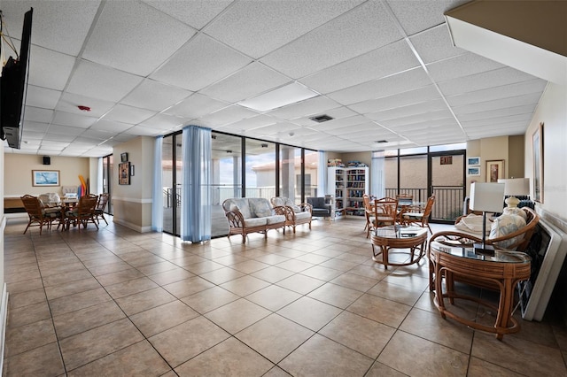 tiled living room with expansive windows and a paneled ceiling