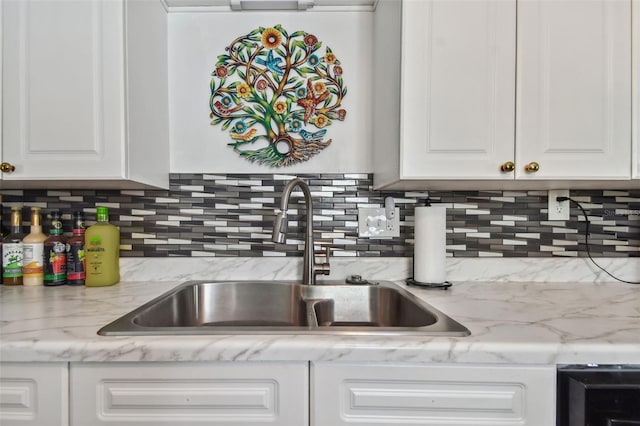 3108 58th St S, Gulfport, FL 33707 - kitchen with a sink, decorative backsplash, white cabinetry, and light stone counters