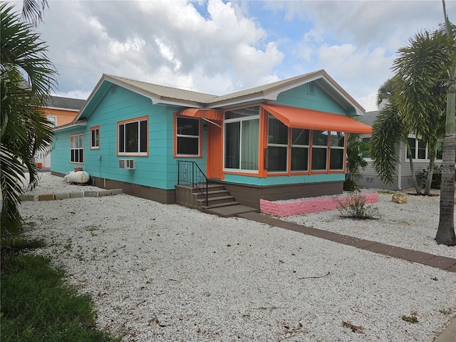 3108 58th St S, Gulfport, FL 33707 - view of front facade featuring a sunroom, an AC wall unit, and crawl space