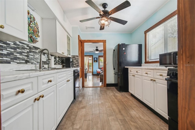 3108 58th St S, Gulfport, FL 33707 - kitchen featuring a ceiling fan, black appliances, a sink, light wood finished floors, and backsplash