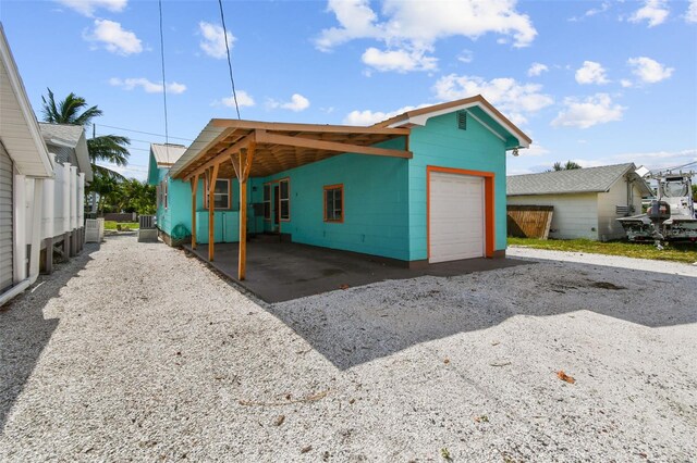 back of house featuring central AC and a carport