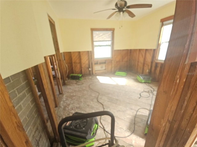 spare room featuring ceiling fan and wooden walls