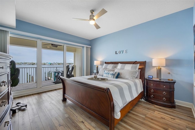 bedroom featuring ceiling fan, light hardwood / wood-style flooring, and access to exterior