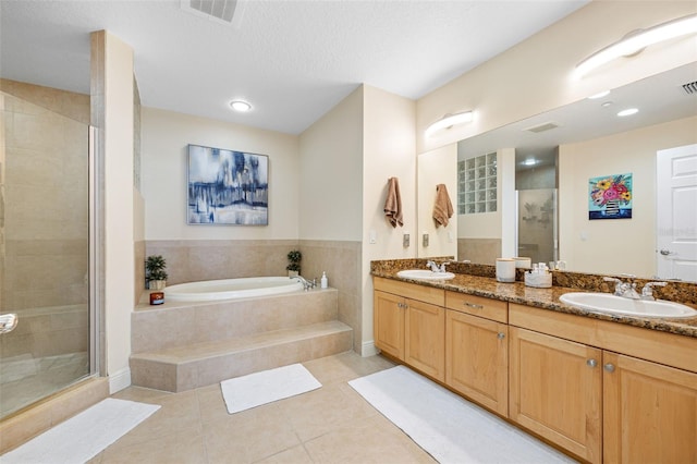 bathroom featuring tile patterned floors, a textured ceiling, plus walk in shower, and vanity