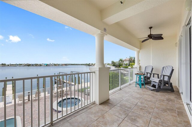 balcony with ceiling fan and a water view