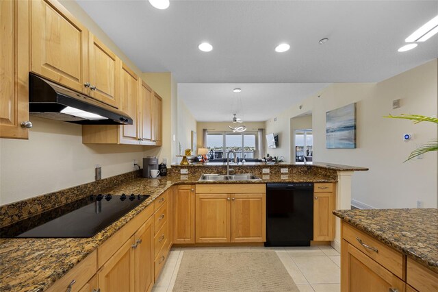 kitchen featuring light tile patterned floors, sink, dark stone countertops, kitchen peninsula, and black appliances