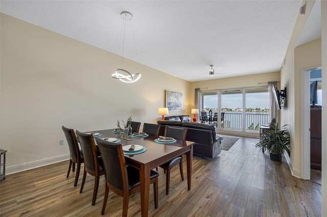 dining space featuring ceiling fan and dark wood-type flooring