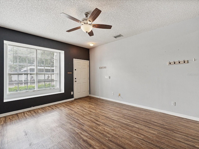 empty room featuring ceiling fan, a textured ceiling, and hardwood / wood-style floors