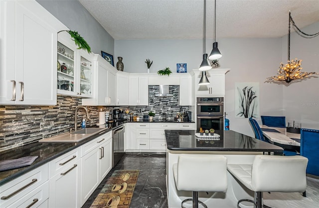 kitchen with decorative backsplash, a kitchen breakfast bar, sink, a textured ceiling, and stainless steel appliances