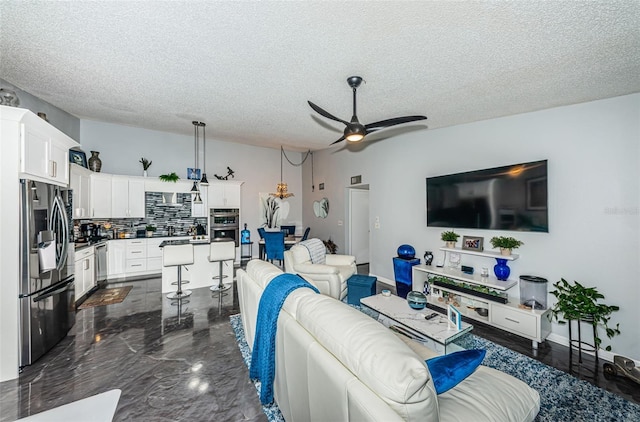 living room with ceiling fan and a textured ceiling