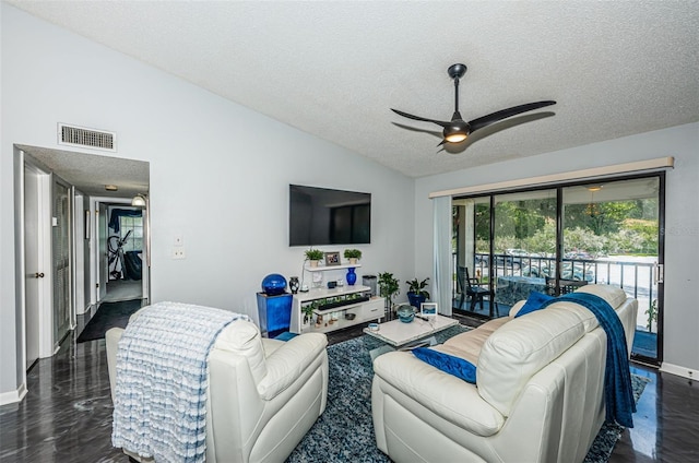 living room with ceiling fan, vaulted ceiling, and a textured ceiling