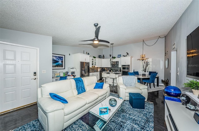 living room featuring a textured ceiling, ceiling fan, and wood-type flooring