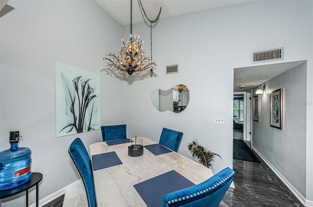 tiled dining space featuring a textured ceiling, high vaulted ceiling, and a chandelier