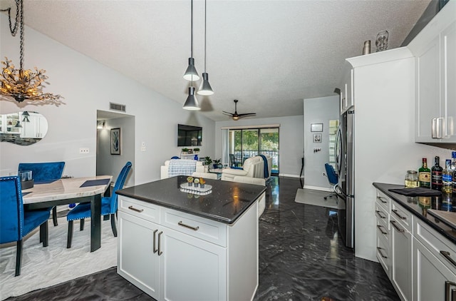 kitchen with ceiling fan, white cabinets, stainless steel refrigerator, vaulted ceiling, and dark tile patterned flooring