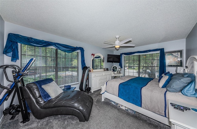 carpeted bedroom featuring a textured ceiling and ceiling fan