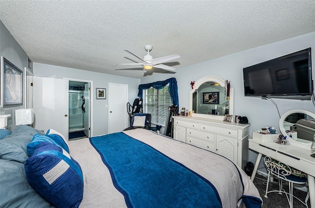 carpeted bedroom featuring ceiling fan, a textured ceiling, and ensuite bathroom