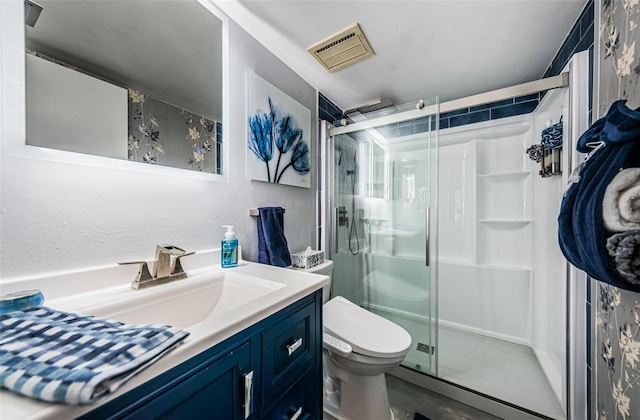 bathroom featuring vanity, walk in shower, and toilet