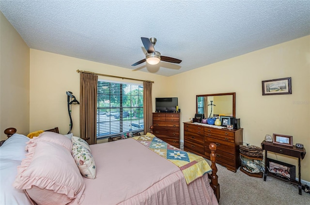 carpeted bedroom with ceiling fan and a textured ceiling