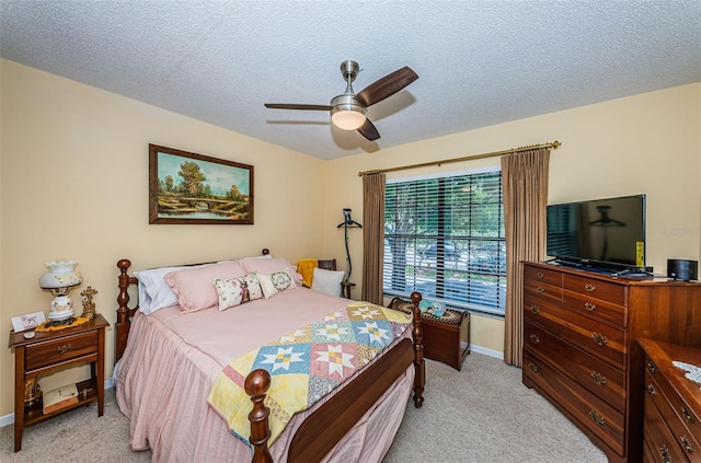 carpeted bedroom with ceiling fan and a textured ceiling