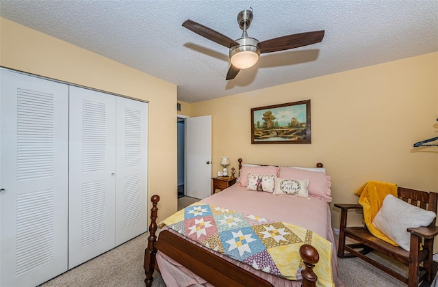 carpeted bedroom featuring ceiling fan, a closet, and a textured ceiling