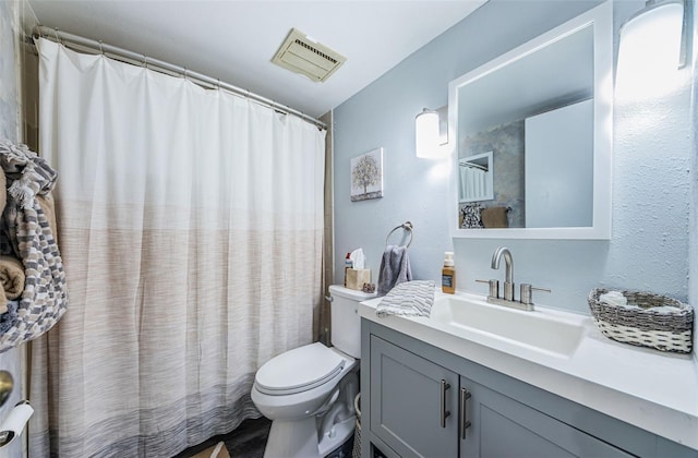 bathroom featuring toilet, vanity, and a shower with curtain