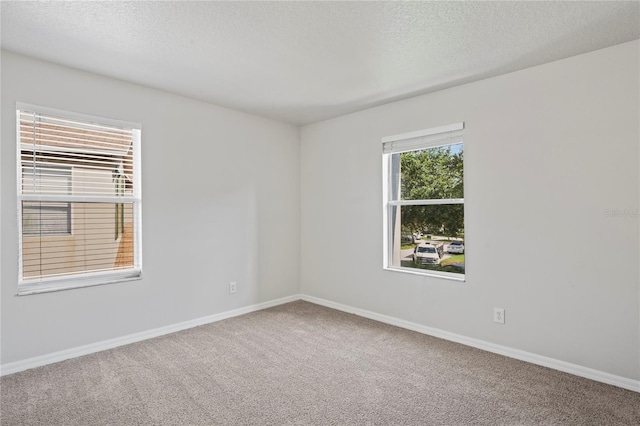 carpeted spare room featuring a textured ceiling