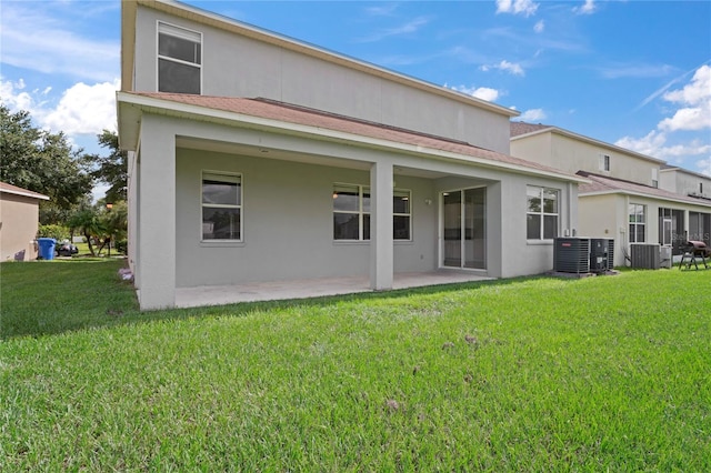 back of house with central AC, a lawn, and a patio area